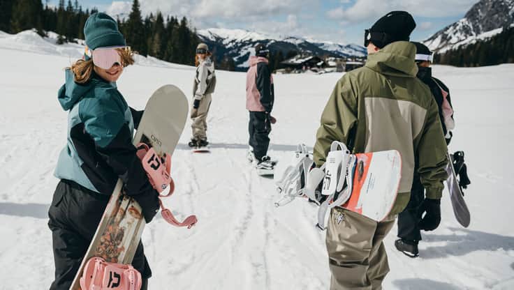A snowboarder just crossing the parkinglot
