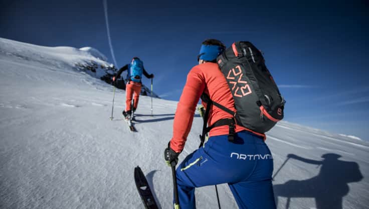 Skier hiking up the mountain with the Avabag avalanche backpack by Ortovox