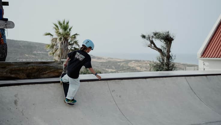 Junge skateboardet in der Bowl. Er macht einen Stalefish Aerial.