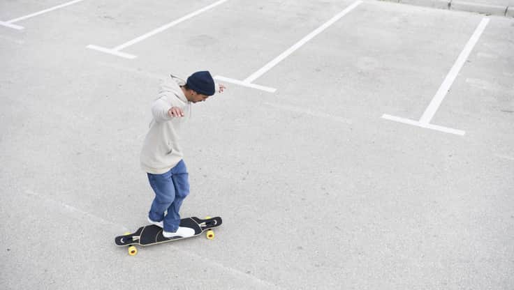 Junger Mann skatet auf seinem Longboard