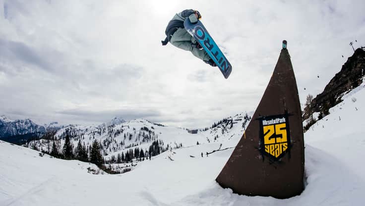 Snowboarder sitting on a bench