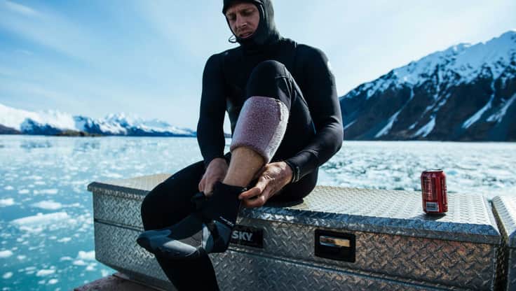 Pro-Surfer Mick Fanning zieht seine Surf Boots an in Alaska